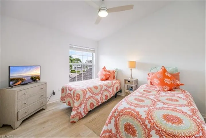 Bedroom featuring ceiling fan, light hardwood / wood-style flooring, and lofted ceiling