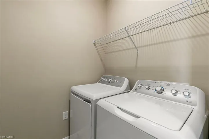Dedicated laundry area featuring a wire shelving unit
