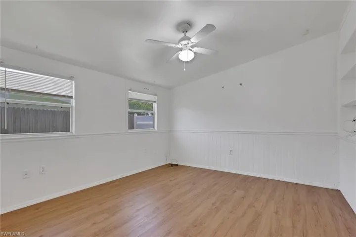 Light wood-finish flooring with white walls featuring wainscoting
