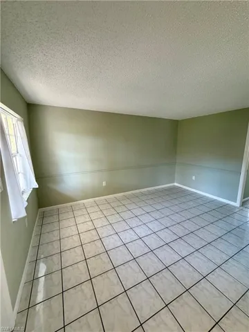 Spare room with a textured ceiling and tile patterned floors