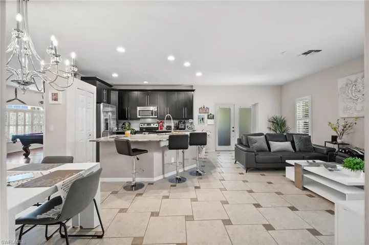 Living room featuring recessed lighting, pool table, a chandelier, and baseboards