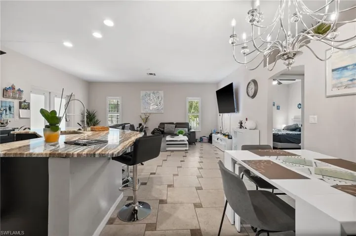 Kitchen featuring a kitchen bar, recessed lighting, open floor plan, a chandelier, and a center island with sink