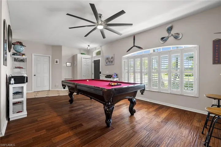 Playroom featuring pool table, a ceiling fan, wood finished floors, and baseboards