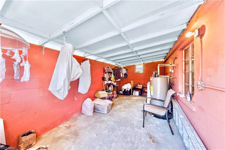 Garage featuring water heater and concrete block wall