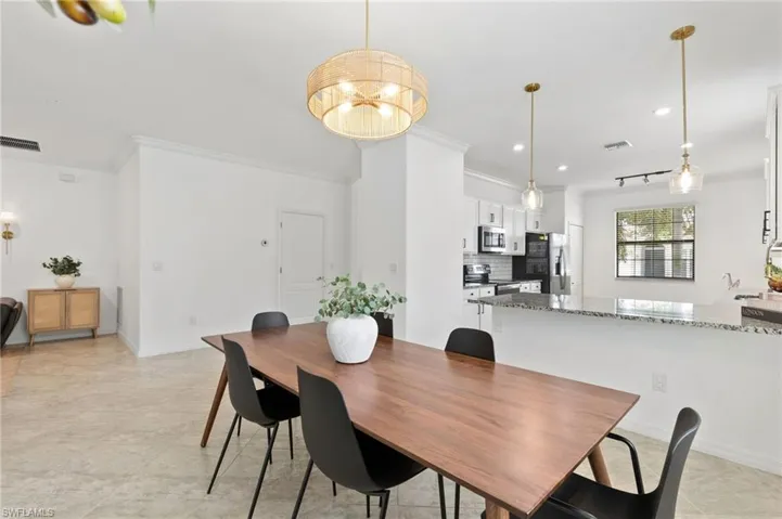 Dining area with ornamental molding and recessed lighting