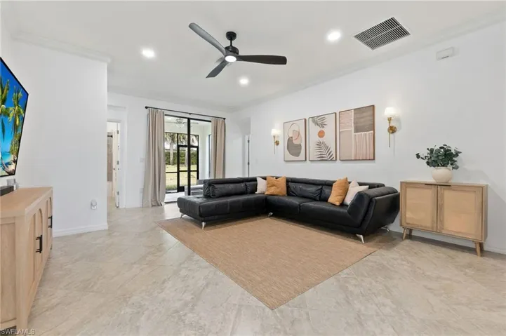 Living room featuring ornamental molding, recessed lighting, and ceiling fan