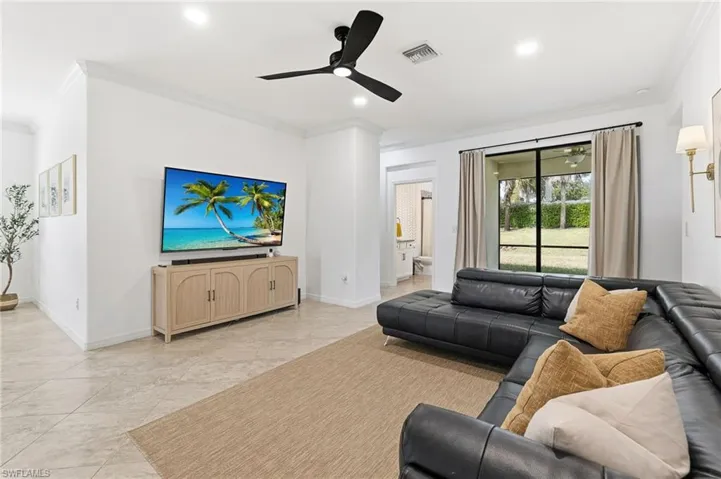 Living room with ornamental molding, ceiling fan, and recessed lighting