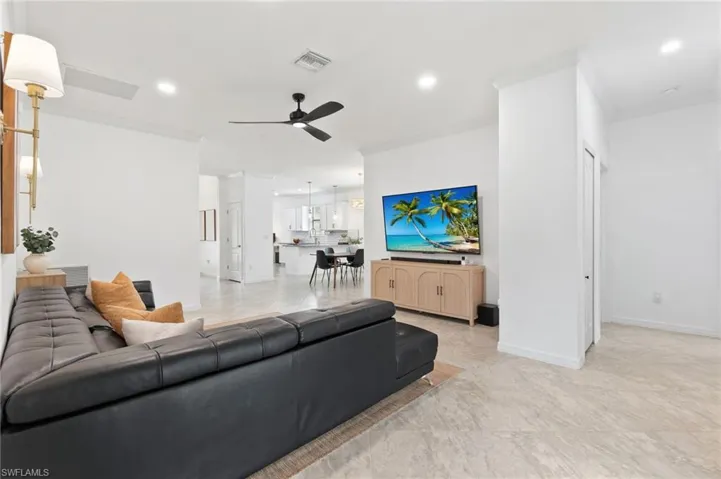 Living area with ornamental molding, recessed lighting, and ceiling fan