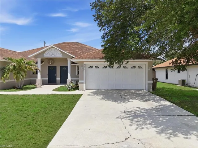 Exterior facade with a two-car garage, concrete driveway, and covered entry