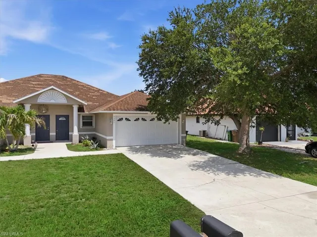 Tan stucco exterior with white trim, featuring a two-car garage with a white door