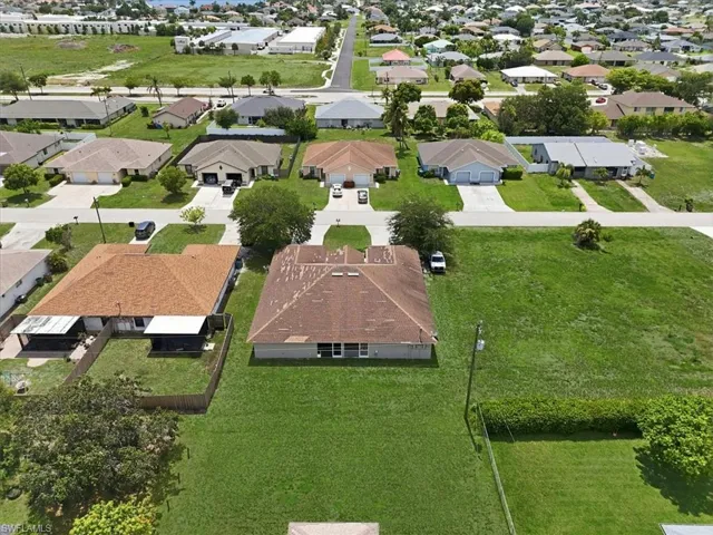 Single-story residence with a light brown shingle roof and a spacious, manicured lawn