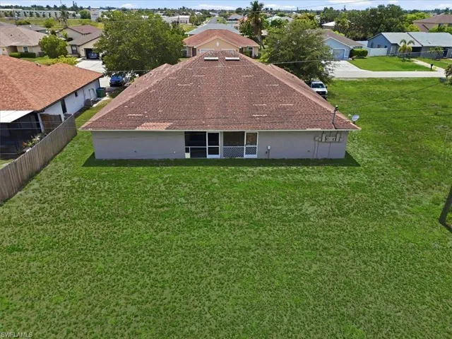 Expansive rear lawn featuring a privacy fence along one boundary