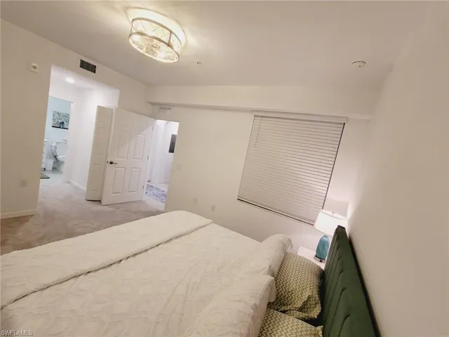 Carpeted bedroom featuring lofted ceiling