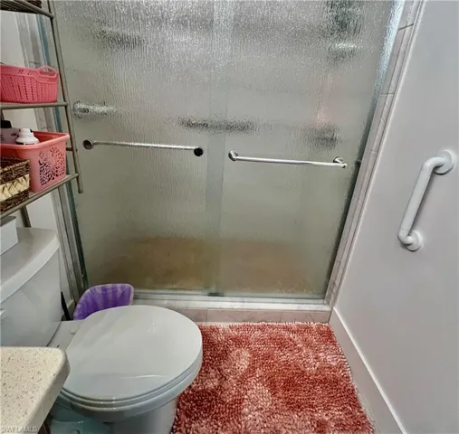 Bathroom featuring walk in shower and toilet