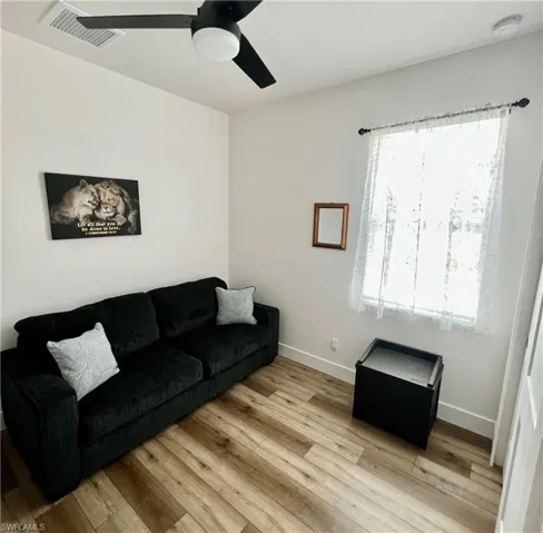 Living room with plenty of natural light, ceiling fan, and light hardwood / wood-style flooring