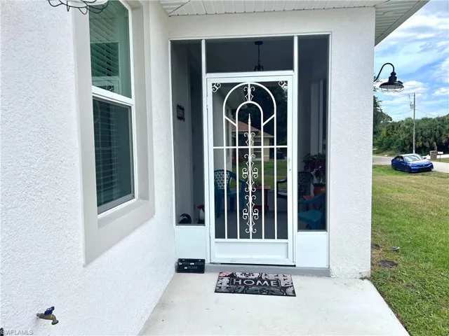 View of exterior entry with a yard