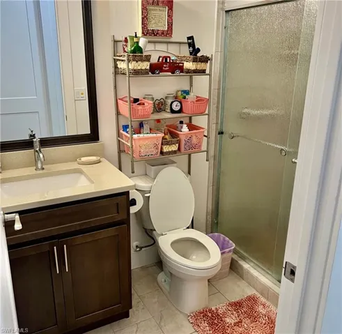 Bathroom with walk in shower, vanity, toilet, and tile floors