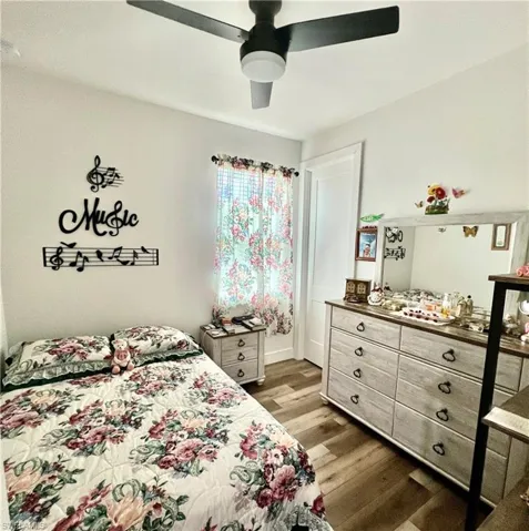 Bedroom with ceiling fan and hardwood / wood-style flooring
