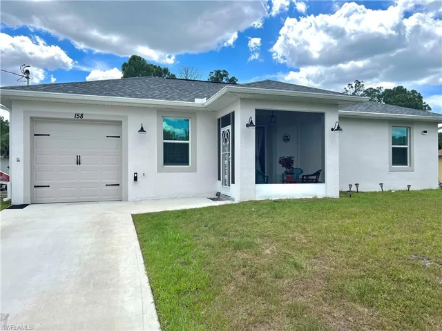 Ranch-style home with a front yard and a garage