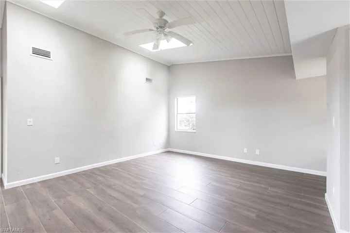 Empty room with wood ceiling, a ceiling fan, and dark wood finished floors