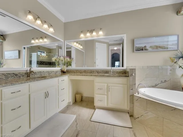 Bathroom with vanity, ornamental molding, a bath, and a shower stall