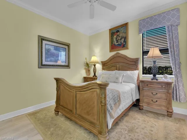 Bedroom featuring crown molding, light wood-style floors, and a ceiling fan