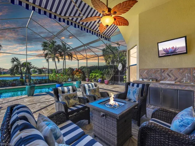 Patio terrace at dusk featuring an outdoor living space with a fire pit, an outdoor pool, a lanai, and a patio
