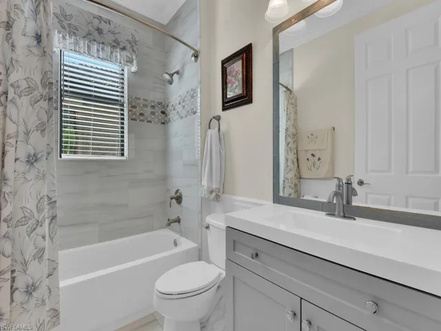 Full bath featuring healthy amount of natural light, shower / bath combo, and vanity