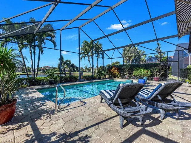 Outdoor pool with a patio area and glass enclosure