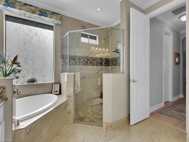 Full bath featuring ornamental molding, a garden tub, a stall shower, and recessed lighting