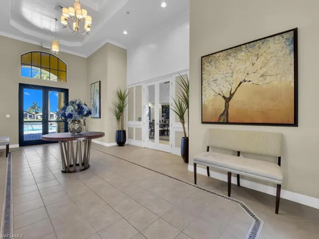 Common area with a high ceiling, ornamental molding, and recessed lighting