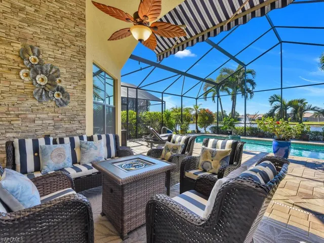 View of patio / terrace with an outdoor living space with a fire pit, an outdoor pool, ceiling fan, and glass enclosure