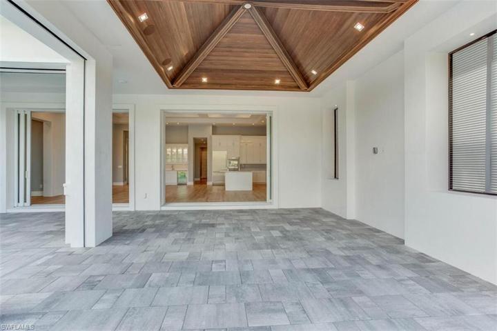 EXTENDED COVERED LANAI, EXPANSIVE HEIGHT VAULTED CEILLING,RECESSED FAUX WOOD BEAMS & 5" CYPRESS TONGUE & GROOVE, IN CEILING WAP, SONOS SPEAKERS. MOTORIZED RETRACTABLE SCREENS & HIGH VELOCITY IMPACT-RATED HURRICANE SHUTTERS