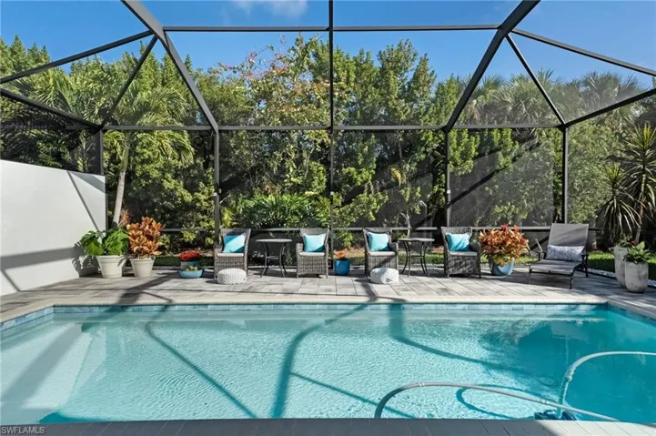 The expansive pavered pool deck surrounds a sparkling turquoise pool, ideal for entertaining or unwinding. Thanks to its northern rear exposure, the area is sunlit all day, creating the perfect outdoor retreat.