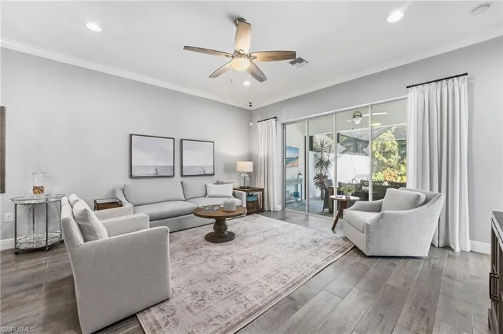 The open-concept living space boasts tile flooring throughout and effortlessly connects to the lanai and pool, creating a bright and inviting indoor-outdoor flow.