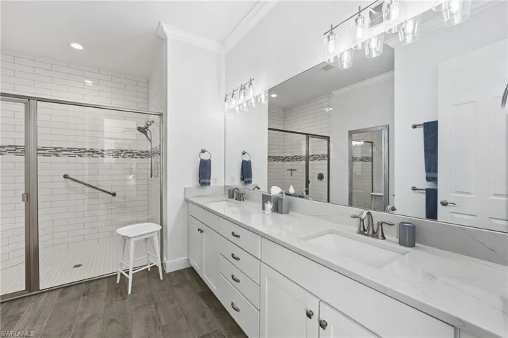 The primary ensuite bath features a walk-in shower, dual sparkling white quartz vanities, and a private water closet, combining elegance and functionality.