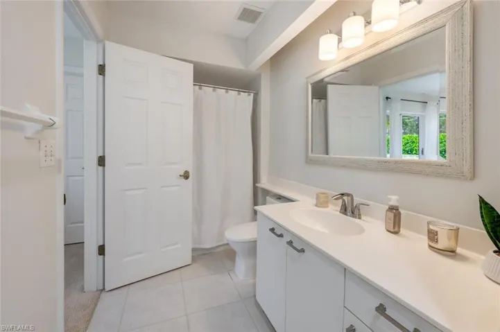 Bathroom featuring vanity, toilet, and tile patterned flooring