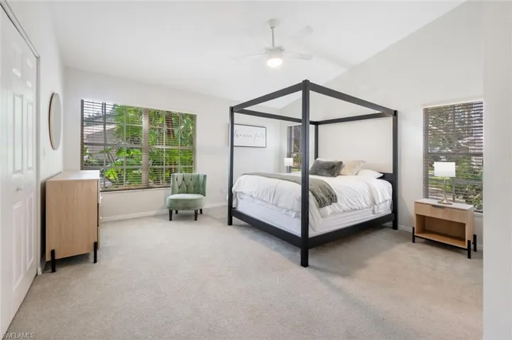 Bedroom with a closet, ceiling fan, and light carpet