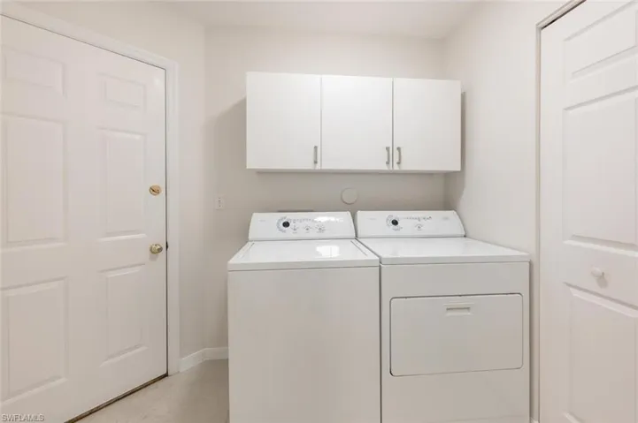 Laundry area featuring cabinets and separate washer and dryer