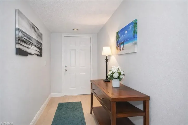 Doorway to outside with wood finished floors and a textured ceiling