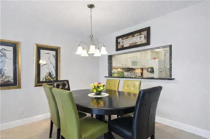 Dining room with suspended lighting, a textured ceiling, and light wood-style flooring
