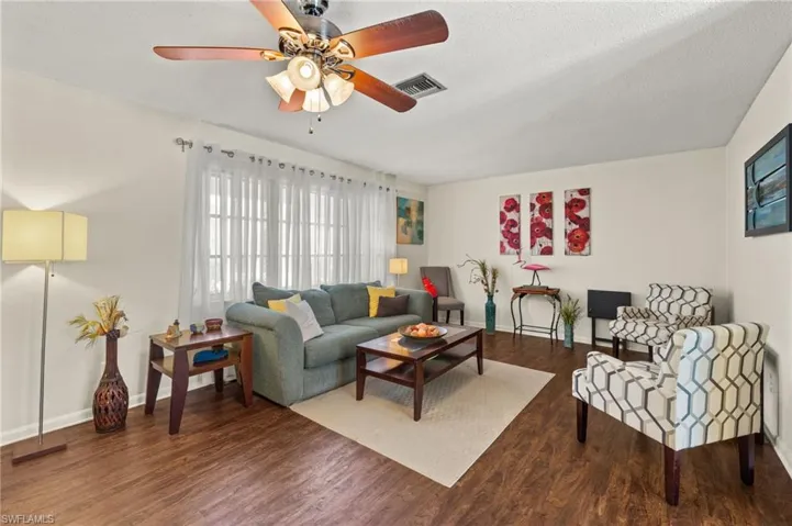 Living area with a ceiling fan and wood finished floors