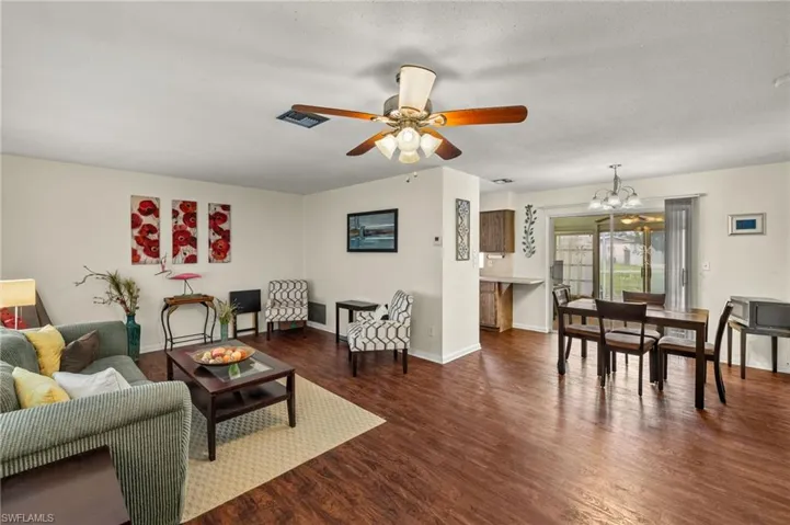Living room featuring a chandelier, wood finished floors, and a ceiling fan