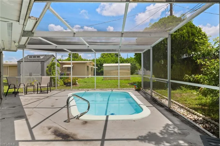 Swimming pool with a shed, a patio, and glass enclosure