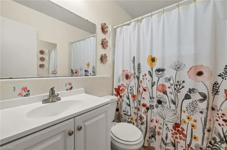 Full bath with vanity, a shower with curtain, and tile walls