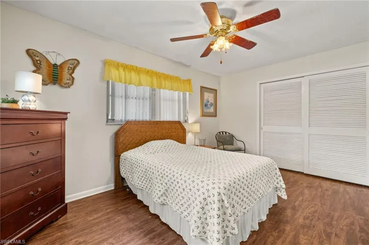 Bedroom with a closet, dark wood-style flooring, and ceiling fan