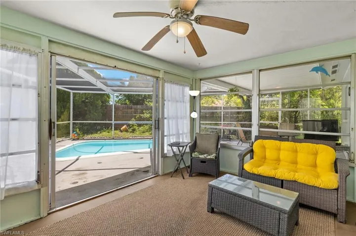Sunroom / solarium featuring ceiling fan and a swimming pool