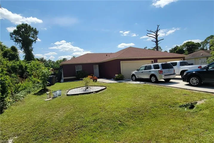 Ranch-style house featuring an attached garage, a front yard, and concrete driveway