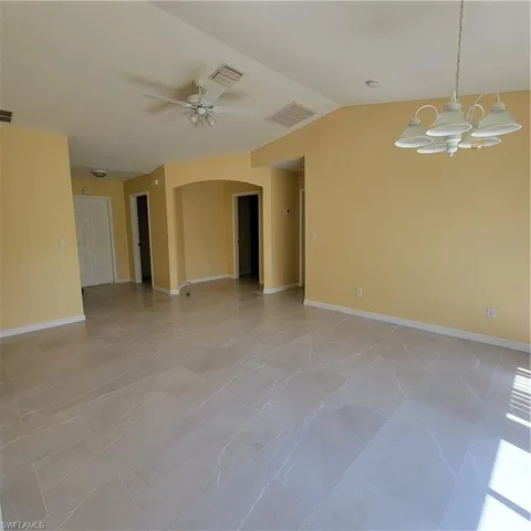 Unfurnished room with lofted ceiling and a ceiling fan