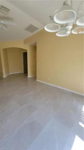 Empty room with baseboards and arched walkways